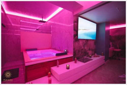雅西普莱达Spa精品酒店的粉红色的浴室设有浴缸和电视。