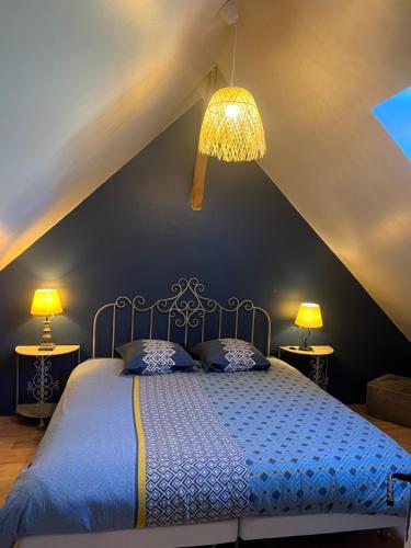 瑟泽Gite de la Pilaudiere的一间卧室配有一张蓝色的床和两盏灯。