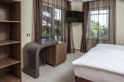 瓦尔纳公爵酒店的卧室配有一张床、一张书桌和窗户。