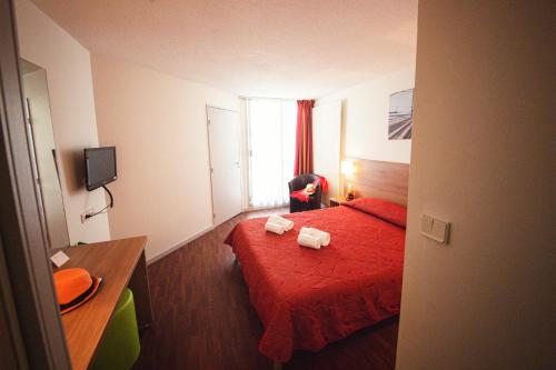 乌瑞基尼VVF Urrugne Saint-Jean-de-Luz Côte Basque的酒店客房,配有红色的床和两条毛巾