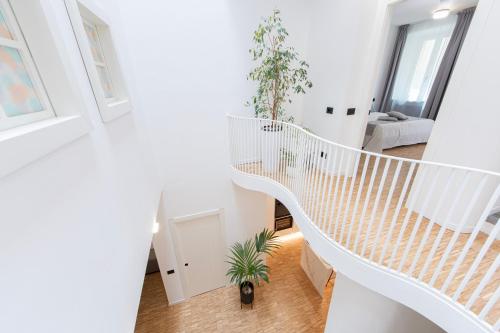 阿罗纳cavaedium guest house的白色房间中的白色螺旋楼梯