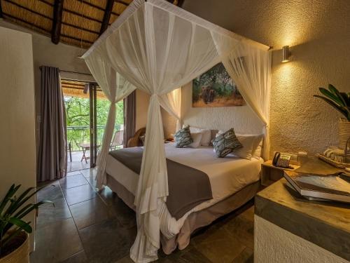 雾观Umbhaba Eco Lodge的一间卧室配有一张带天蓬的床