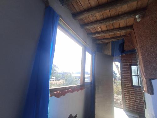 皮里亚波利斯Hostel Morgan的窗户,有蓝色窗帘的房间