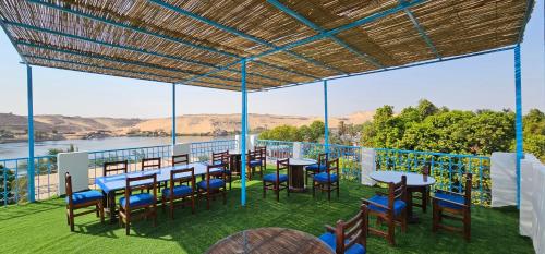 阿斯旺Basmatic Nubian Guest House的一个带桌椅的庭院,享有水景