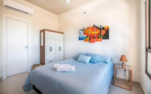 LuqueDelicado Monoambiente-comfy Studio的卧室配有蓝色的床和墙上的绘画作品