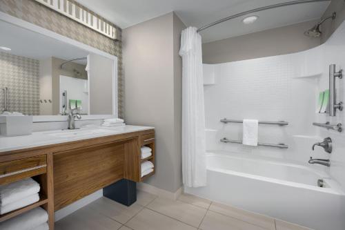 杰克逊维尔Home2 Suites by Hilton Jacksonville, NC的浴室设有白色浴缸、水槽和浴缸。