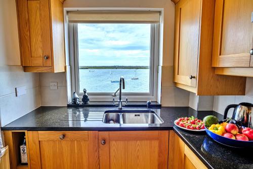 克劳奇河畔伯纳姆Finest Retreats - Kings Wharf - Luxury Riverside Home的厨房设有水槽、窗户和一碗水果