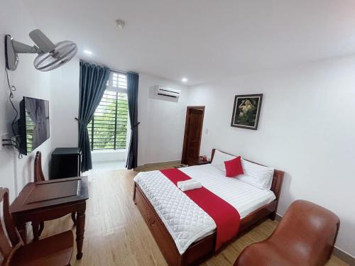 胡志明市Thiên Phát Hotel - SECC的一间卧室配有一张床、一张桌子和一把椅子