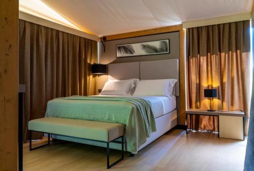 斯培基奥拉Infinito Resort的一间卧室配有一张床和长凳