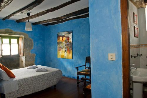 Atallu新屋乡村民宿的一间卧室设有蓝色的墙壁、一张床和一个水槽