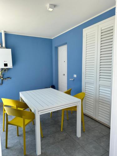 雷卡纳蒂港A casa di Fede的一间设有白色桌子和黄色椅子的用餐室