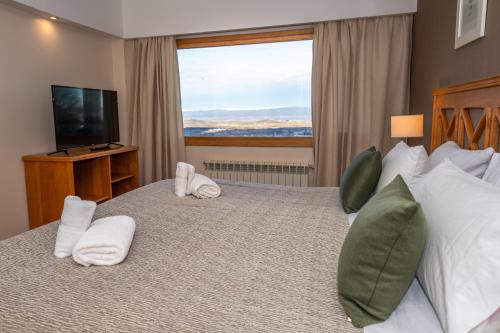 乌斯怀亚Altos Ushuaia Hotel & Resto的酒店客房设有一张大床和大窗户
