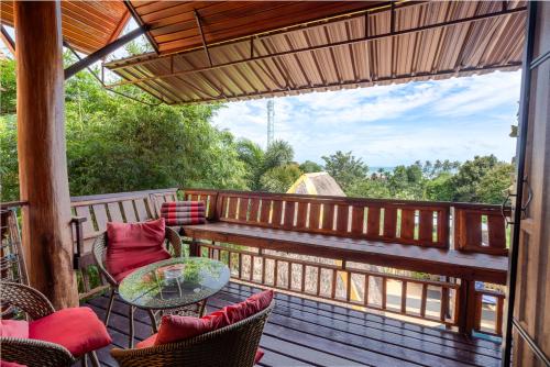 高兰Villa Ayutthaya at Kantiang Bay的阳台配有长凳和桌椅。