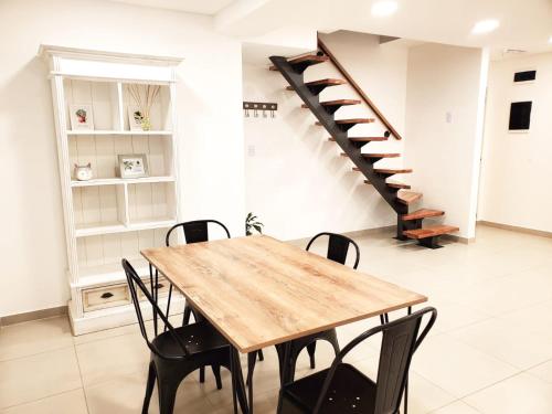 里奥格兰德House Rental RG_Departamento#1的一间带木桌和楼梯的用餐室