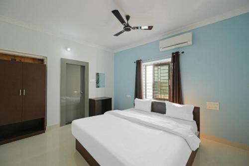 布巴内什瓦尔Goroomgo Grace Premium Bhubaneswar的卧室配有一张白色大床和吊扇