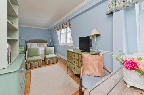 伦敦Veeve - Mews & Blues的一间卧室配有一张床和一张书桌及电视