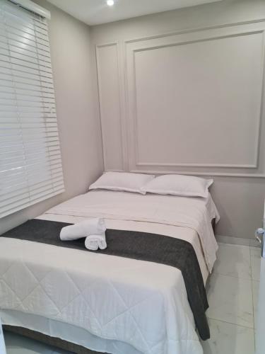 马普托Pousada Calma的白色卧室,配有带毛巾的床