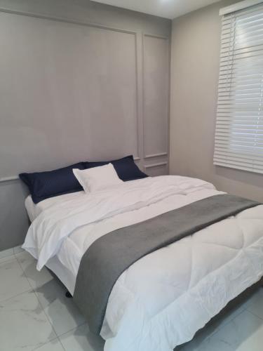 马普托Pousada Calma的卧室配有带蓝色枕头的大型白色床