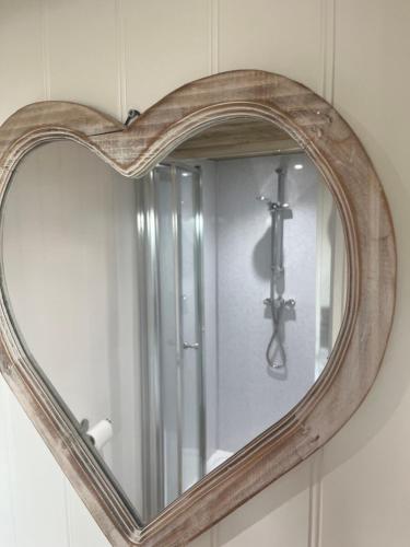 阿博伦The Pod & Cwtch luxury accommodation的墙上的镜子,如心形