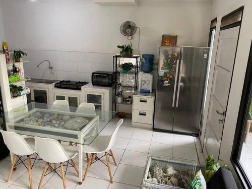 雅加达Coral House - Near Univ Indonesia Setu Babakan的厨房配有桌椅和冰箱。