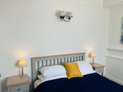 莱姆里吉斯High Tides的一间卧室配有一张带2个床头柜和2盏灯的床。