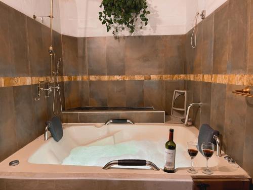 巴里查拉Casa Real Barichara的浴缸配有一瓶葡萄酒和两杯酒