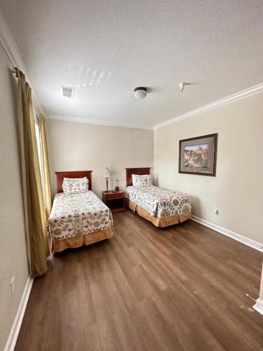 奥兰多前往佛罗里达度假屋的铺有木地板的客房内的两张床