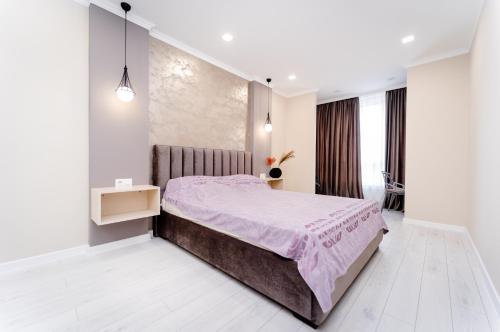 基希讷乌2-Bedroom Family Grandeur Apartment的一间卧室配有一张带粉红色床罩的床