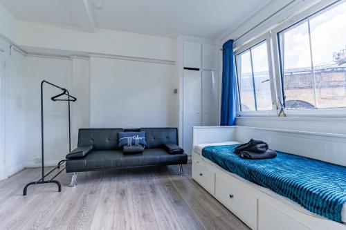 伦敦Bright 1 Bed Flat near London Bridge的卧室配有床、椅子和窗户。