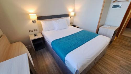 卡拉马Hotel Diego de Almagro Calama Express的一间卧室配有一张带蓝色毯子的大床
