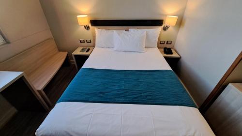 卡拉马Hotel Diego de Almagro Calama Express的小房间设有一张大床,配有两张桌子