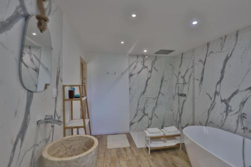 劳恩尼克Gîte Louannec - Ty Bleiz的带浴缸和大理石墙的浴室。