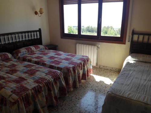 瓜达莱斯特里根迪贝佩旅舍的一间卧室设有两张床和窗户。