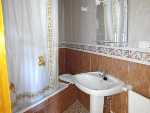 瓜达莱斯特里根迪贝佩旅舍的一间带水槽、镜子和淋浴的浴室
