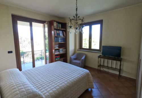 瓜尔多卡塔内奥Lavanda - Villa Rita的一间卧室设有一张床、一台电视和窗户。