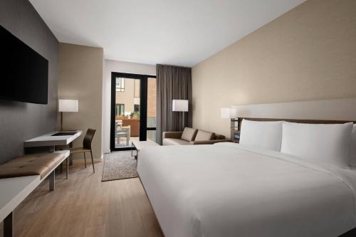圣罗莎AC Hotel by Marriott Santa Rosa Sonoma Wine Country的酒店客房设有一张白色大床和一张沙发。