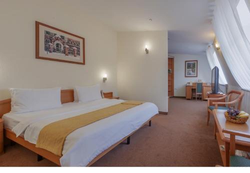 克拉斯诺亚尔斯克多姆经典酒店的一间卧室配有一张大床和一张桌子