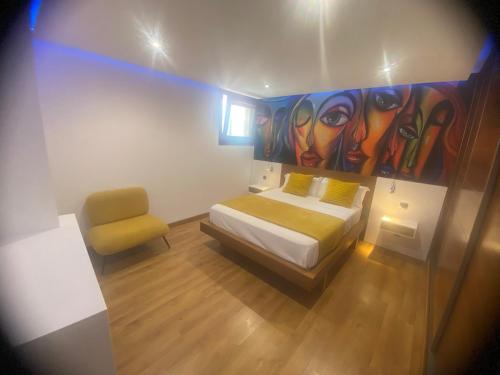 加拉奇科Modern sea front apartment in Garachico 3的卧室配有一张床,墙上挂有绘画作品