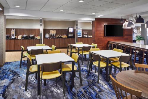 盖恩斯维尔Fairfield Inn & Suites by Marriott Gainesville的用餐室配有桌子和黄色椅子