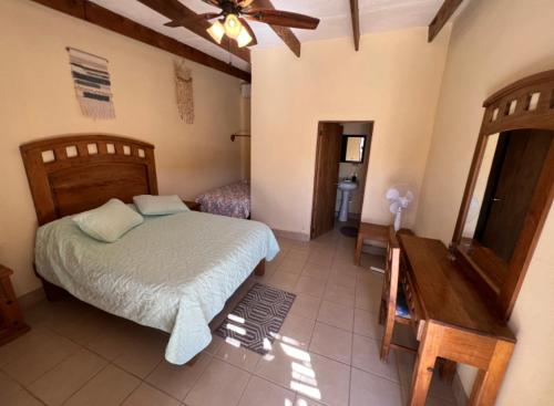 Punta ArenaPlaya Posada Eco Rooms的一间卧室配有一张床和吊扇