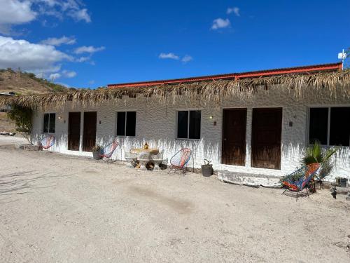 Punta ArenaPlaya Posada Eco Rooms的前面有桌椅的建筑