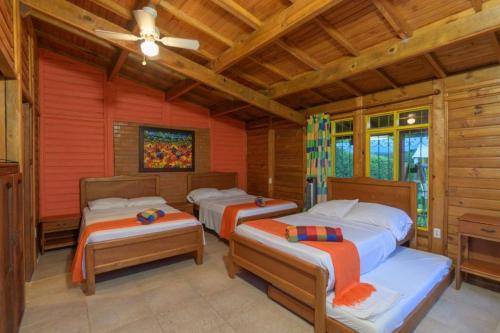 金巴亚Cabitat Cabañas的带木墙的客房内的三张床