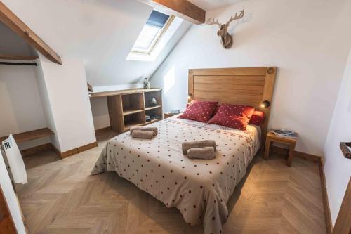 圣拉里苏朗Le Rioumajou 2的一间卧室配有一张带木制床头板的床