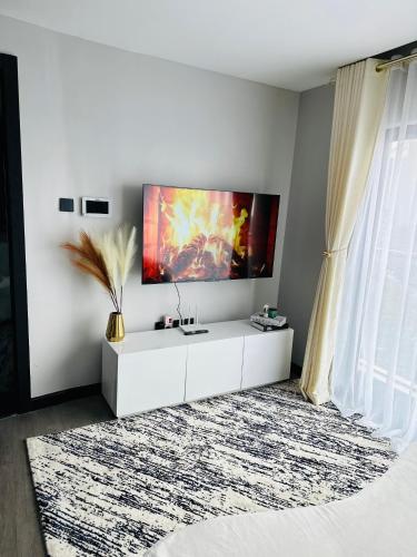 内罗毕Escada的白色的客厅墙上配有电视