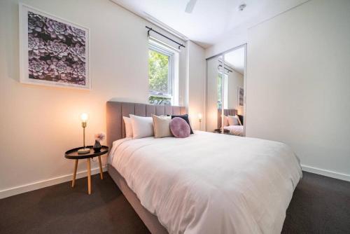 阿德莱德Floral on Frew Adelaide的卧室设有一张白色大床和一扇窗户。