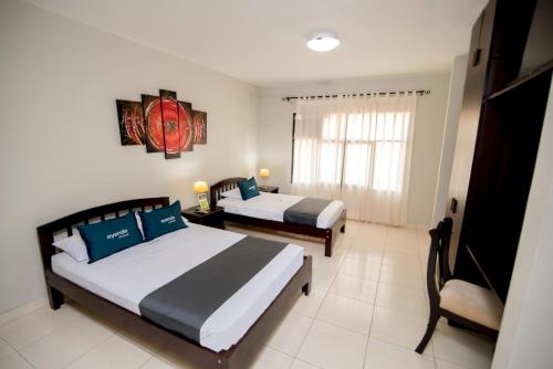 皮乌拉Hotel Casa Real Piura的酒店客房设有两张床和窗户。