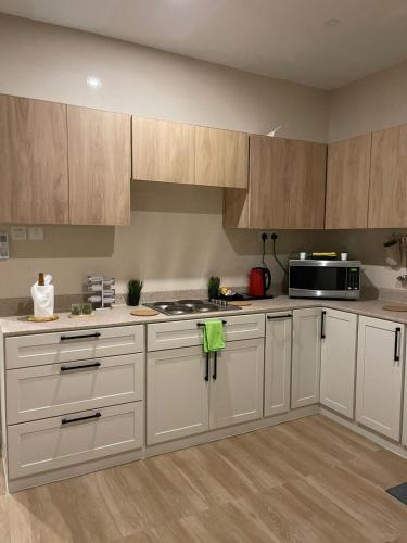 阿可贺巴Family Furnished Apartment in Khobar的厨房配有白色橱柜和微波炉