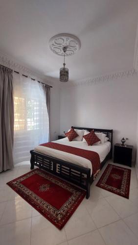 丹吉尔Emplacement idéal的一间卧室配有一张带两张地毯的床