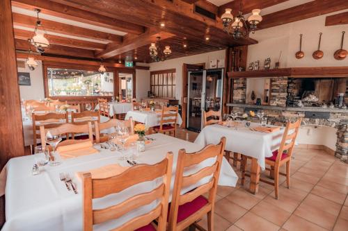 Chermignon-dʼen BasRelais Fleuri的餐厅设有白色的桌子和木椅