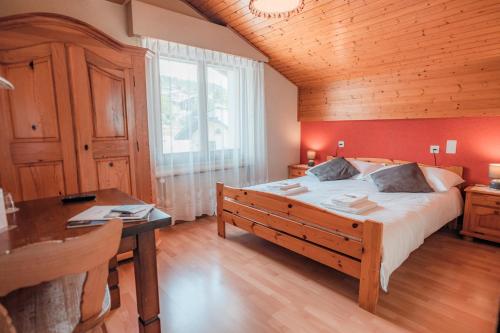 Chermignon-dʼen BasRelais Fleuri的一间卧室设有一张大床和木制天花板